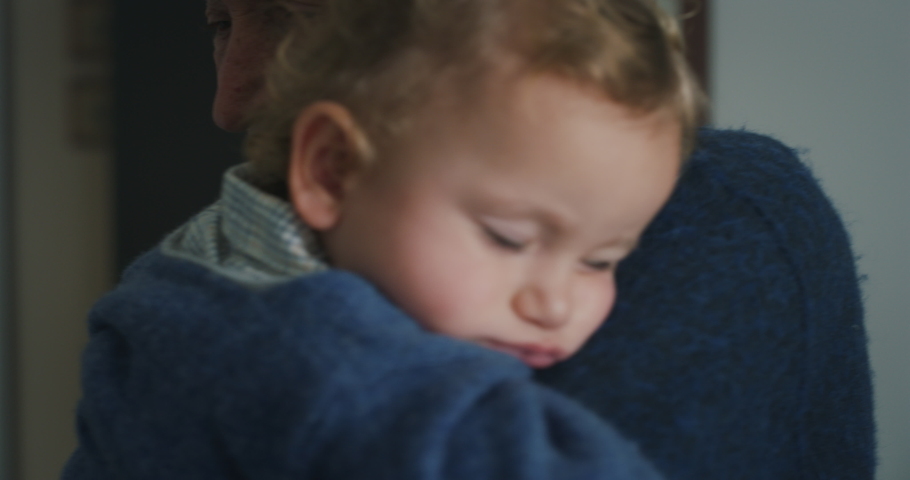 Cinematic close up shot of senior gray hair grandfather is cuddling a grandson baby while sleeping peacefully on  his arms at home.Concept of life, grandparents, love, care, generation, childhood Royalty-Free Stock Footage #1062429136