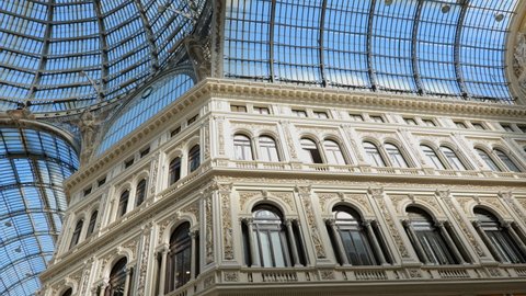Naples, Campania, Italy - Circa September, 2020: Galleria Umberto I, public shopping gallery and city landmark built in 1887–1891, panning and tilt down to the floor with group of people, tourists.