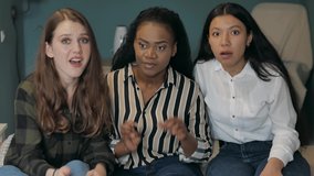 Diverse football fans females  watching tv match. Happy multi ethnic friends watching sports on TV. Real joyful emotions. Passionate football supporters scream with arms raised, celebrating win goal - Powered by Shutterstock - Get 15% off with code: PIKWIZARD15