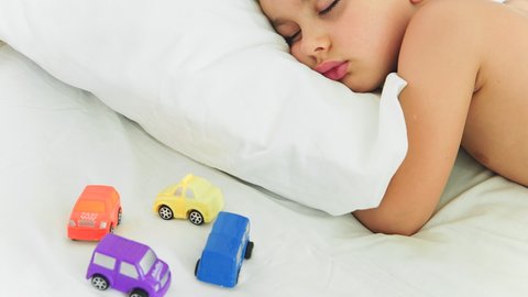STOP MOTION: A Child sleeps and a toy cars is moving