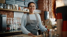 Beautiful Latin American Female Barista with Short Hair and Glasses is Projecting a Happy Smile in Coffee Shop Bar. Portrait of Happy Employee Behind Cozy Loft-Style Cafe Counter in Restaurant. - Powered by Shutterstock - Get 15% off with code: PIKWIZARD15