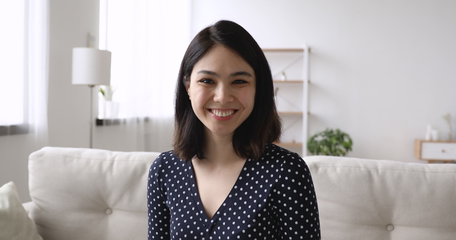 Web camera view happy young korean asian mixed race woman sitting on sofa, involved in distant video call conversation with friends or passing job interview remotely from home, feeling confident. Royalty-Free Stock Footage #1062437992