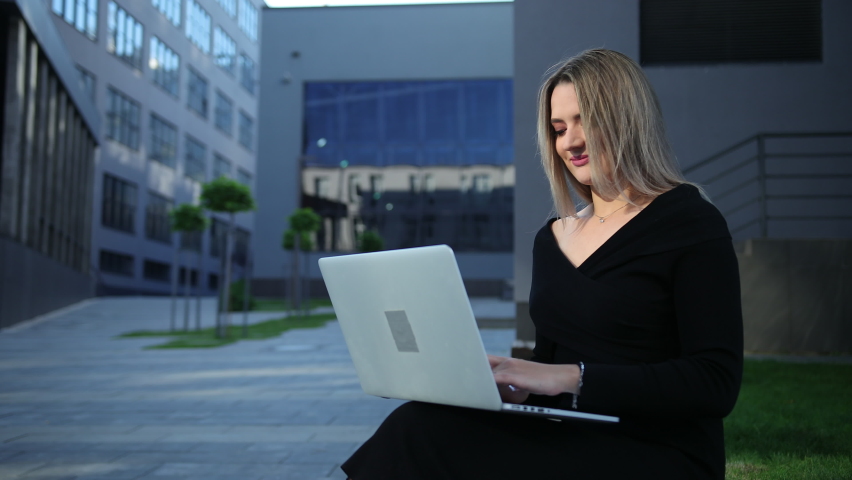 Young business woman with laptop outside the street. businesswoman sitting. Student lady using a computer. female resting.