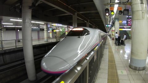 TOKYO / JAPAN - JULY 2019: E2 Series Shinkansen bullet train in Ueno JR railway station of Tokyo, Japan, Asia. Modern transportation, fast travel, Japanese travelers and Asian commuters on platform