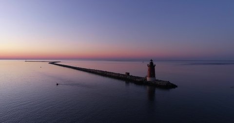 Delaware Breakwater Lighthouse during sunset, aerial drone shot, seagull flies overhead