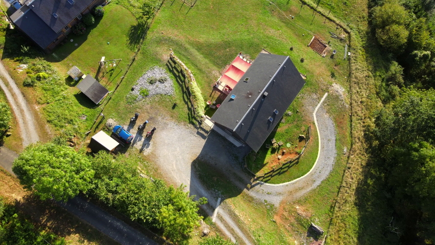 Aerial view of two buildings, roads, parked vehicles, trees, and more