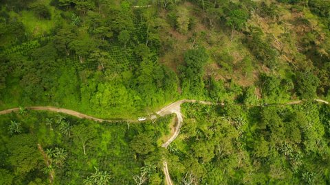 Drone shot flying over beautiful mountain ridge in rural jungle bush forest of Sierra Nevada Colombia viewing the trees, plants, fields, roads coffee plantation and mountains 4k fly away shot