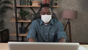 Confident young african businessman in face mask office workplace. Remote chatting colleague internet online meeting conference webinar. Distance work webcam. Coronavirus health care 4k - Powered by Shutterstock - Get 15% off with code: PIKWIZARD15