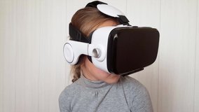 Teenager girl playing using VR glasses. Beautiful young girl wearing virtual reality headset. Augmented Reality.