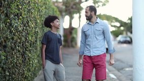 Father mentoring son. Dad and young boy walking together in sidewalk talking. - Powered by Shutterstock - Get 15% off with code: PIKWIZARD15