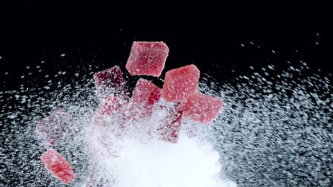 square pieces Handmade Crimson and cherry marmalade flying and falling in white sugar cloud slow motion isolated on black. Sweet taste explosion concept. premium handcrafted confectionary shop ads