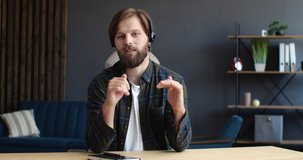 Confident Young Vlogger, Blogger, Coach, Mentor, Businessman talking to the Camera. Handsome Freelancer Businessman  holding Online Conference from Home, wearing Casual Shirts, Headset.