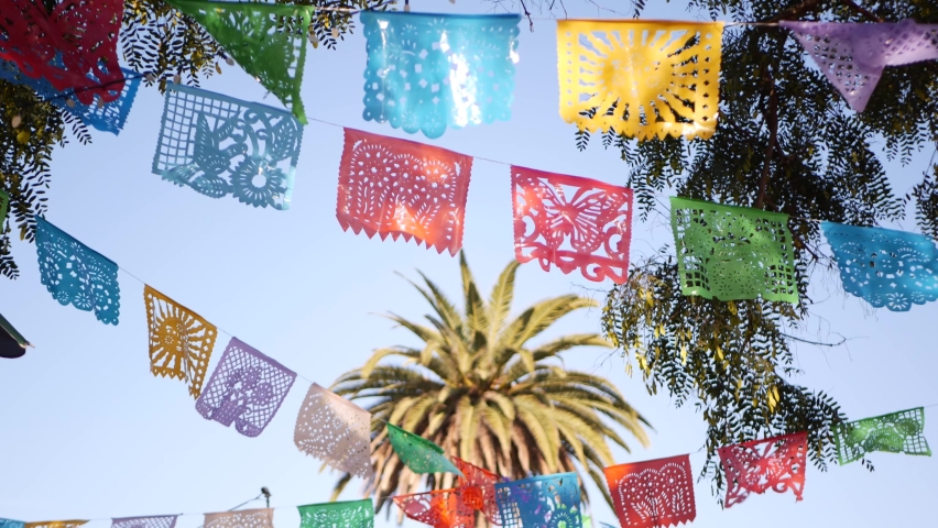 Colorful mexican perforated papel picado banner, festival colourful paper garland. Multi colored hispanic folk carved tissue flags, holiday or carnival. Authentic fiesta decoration in Latin America. Royalty-Free Stock Footage #1062471616