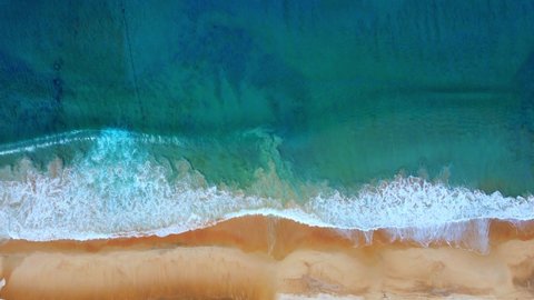 Nature footage travel concept. Aerial view of drone top view beach sea sand. Seawater wave and surf on sandy beach. Beach space area background. Nature and travel concept.