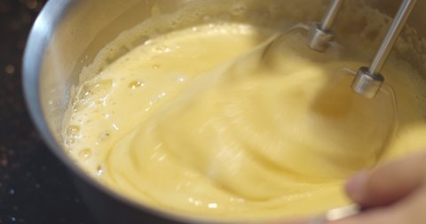 automatic flour mixing machine mixing delicious cream to make cake. ingredient of cake is egg, butter and sugar in the bowl