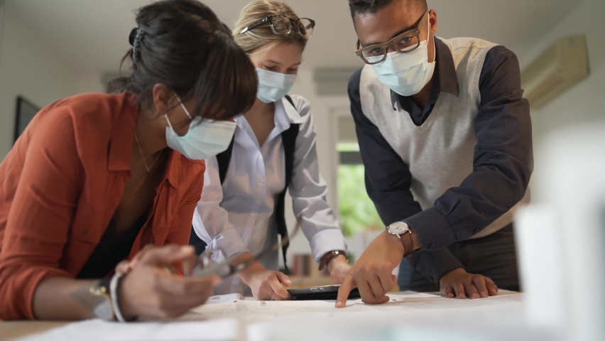 Team of architects working on project, wearing face mask in office Royalty-Free Stock Footage #1062487696