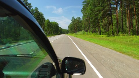 POV: Car is moving across the forest in sunny day on a highway in Altay, Russia