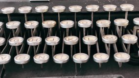 close-up view of the round keys of an old dusty black typewriter. Journalism and storytelling. Writing tool. Right to left panning movement