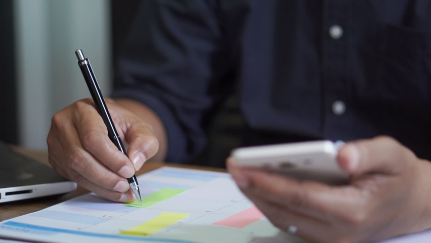 Male hand of planner writing daily appointment On 2022 Calendar book, working space at home. Asian man plan and noted schedule (holiday trip) on the diary at office desk. Calendar for planner concept. Royalty-Free Stock Footage #1062493051