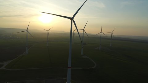 drone flight over a high windmill in Germany , nature environmentally friendly green energy generation while sunset