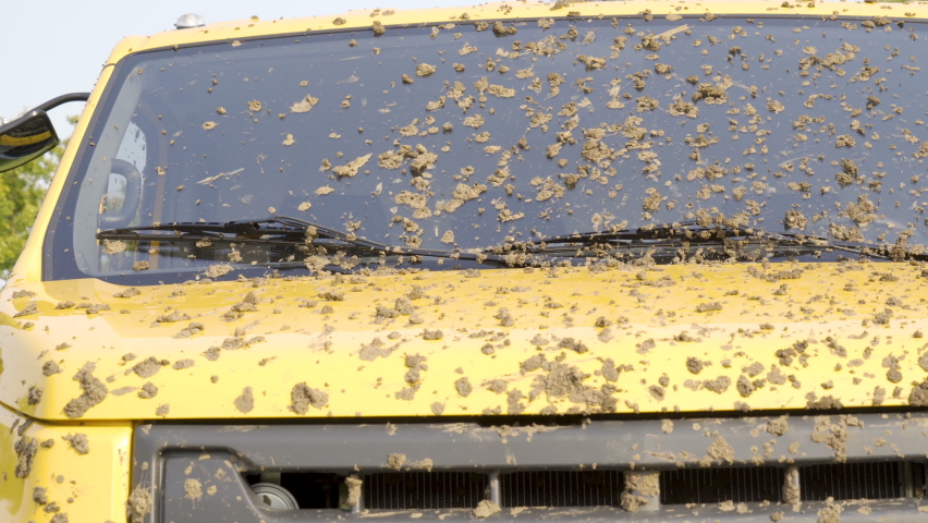 The mud on the yellow old truck in the parking lot after being abandoned