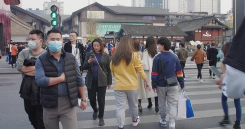 Chengdu,Sichuan/China Nov 17th 2020: crowd of people wear face mask walking at zebra across street at Chunxi road to Sino-Ocean Taikoo Li during Covid-19 pandemic
