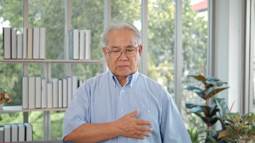 Elderly Asian man with chest pain suffering from heart attack. Man clutching his chest from acute pain. Heart attack symptom-Healthcare and medical concept. Royalty-Free Stock Footage #1062506731