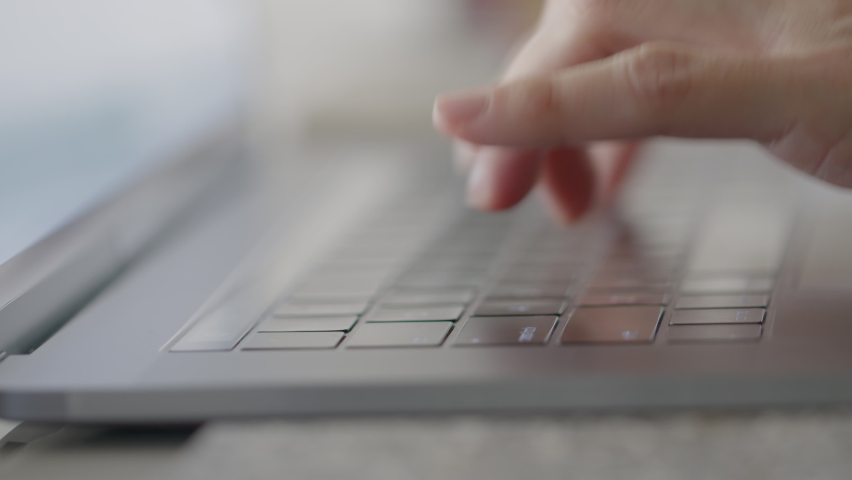 Female hands typing and scrolling on a track pad. Laptop. Detail shot. Shallow depth of field. Lateral dolly. Backlit Royalty-Free Stock Footage #1062509242