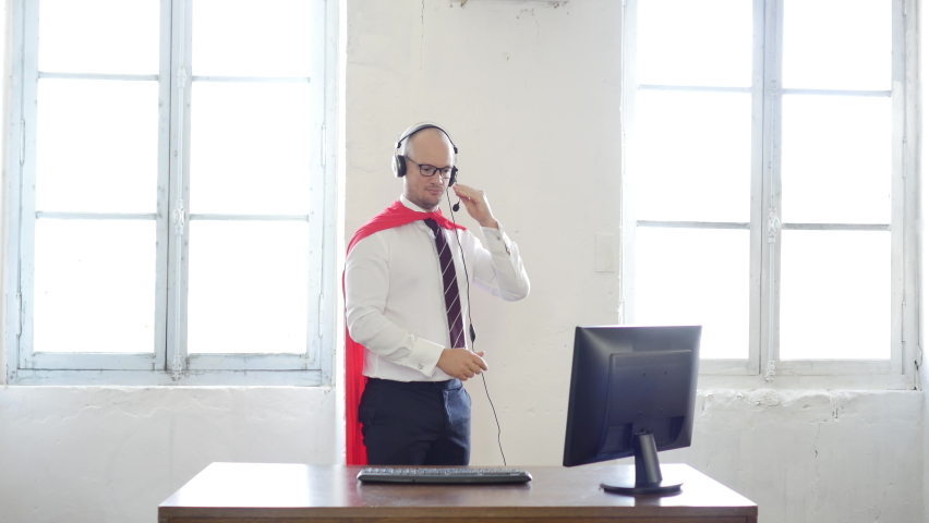 Manager in a superman pose wearing a red cloak. Businessman in a red superhero cloak. super worker, customer service and help. success concept. helpline and business support Royalty-Free Stock Footage #1062516007