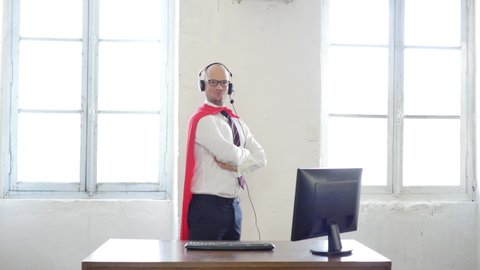 Manager in a superman pose wearing a red cloak. Businessman in a red superhero cloak. super worker, customer service and help. success concept. helpline and business support