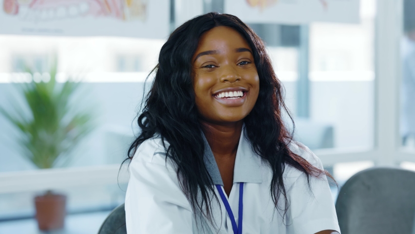 Portrait of beautiful african american woman young intern smiling positively at camera working in hospital reception. Medical employee. Student. | Shutterstock HD Video #1062517186