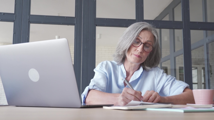 Middle aged business woman talking video conference calling on laptop. Senior older distance teacher communicating in online virtual chat remote meeting looking at computer working from home office. | Shutterstock HD Video #1062522049