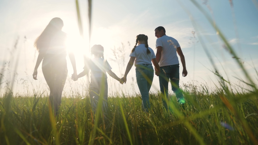 happy family. walk together in the park silhouette. friendly family kid dream concept. happy family walk holding hands in the park on the grass at sunset. friendly family lifestyle dream together Royalty-Free Stock Footage #1062527767