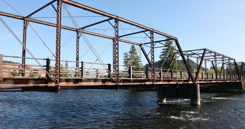 Historical steel span bridge across Madison River Montana 4K. Beautiful mountain river in Teton and Yellowstone areas of Montana and Wyoming. Recreation for rafting, world class fishing.