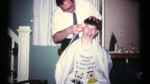 TRENTON, NEW JERSEY, SEPTEMBER, 1972: A loving father gives his teenage son a cool hair cut in the Fall of 1972.