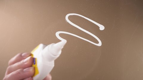 A person applies PVA glue to the surface and glues a piece of cardboard. Bottom view