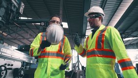 Factory worker warn coworker about safety and give hardhat to him . Injury prevention and safety first concept . - Powered by Shutterstock - Get 15% off with code: PIKWIZARD15