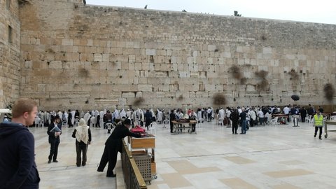 A wide shot with camera panning over the Western wall site, a 4K video clip 29.97 fps, full of praying activity, December 2nd, 2018, old city of Jerusalem, Israel.