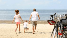 happy family running on a sandy beach