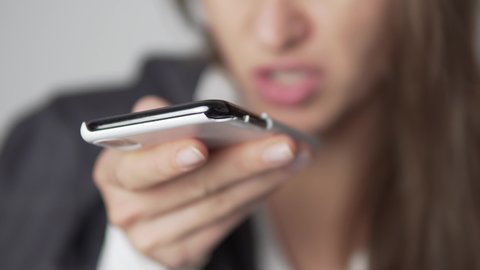 A close-up, the business of the woman in a jacket leaves a voice message on the mobile phone.