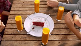 4k above medium video of young budget conscious, multicultural group of friends celebrating a birthday with slice of cake and candles at a cafe. 
