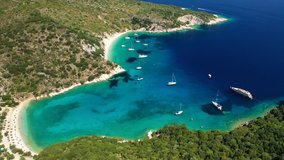Aerial drone video of turquoise paradise sandy beach and bay of Filatro a safe sail boat anchorage in Ithaki or Ithaca island, Ionian, Greece