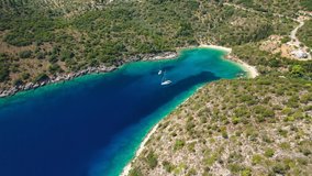 Aerial drone video of turquoise heart shaped paradise sandy beach and bay of Sarakiniko a safe sail boat anchorage in Ithaki or Ithaca island, Ionian, Greece