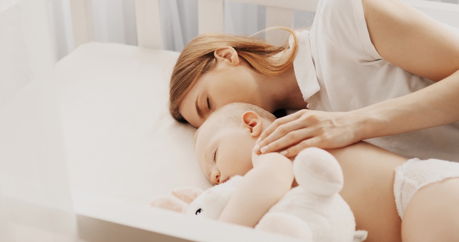 Side view of a beautiful young mother and her cute little baby sleeping Royalty-Free Stock Footage #1062552607