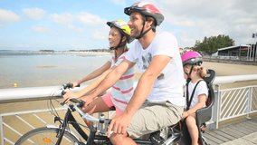Couple with kid riding bicycle on a pontoon