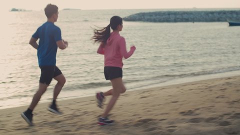 Young man and woman runner running along the beach during beautiful sunset sports training healthy lifestyle concept, active sports workout exercise lifestyle.