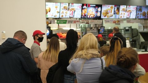 People in masks stand in line inside KFC fast food restaurant during Covid-19 pandemic. Novosibirsk, Russia, 2020