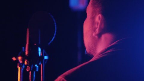 Man singing a song in recording studio - neon lighting