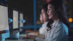 Millennial Asia young call center team or customer support service executive using computer and microphone headset working technical support in late night office. Telemarketing or sales job concept. - Powered by Shutterstock - Get 15% off with code: PIKWIZARD15