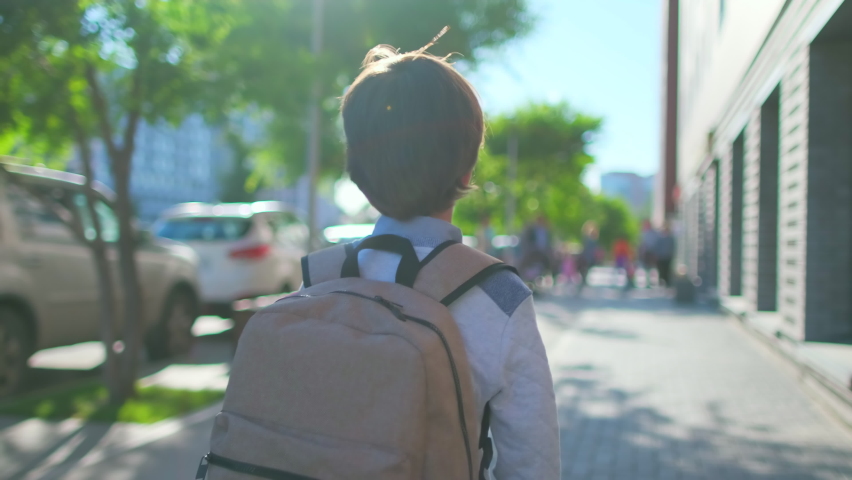 Schoolboy Little boy child with backpack alone going to school at sunset street outdoors. Back view. First-grade student, primary school, first grader, first class education, 4 K slow-mo Royalty-Free Stock Footage #1062578491